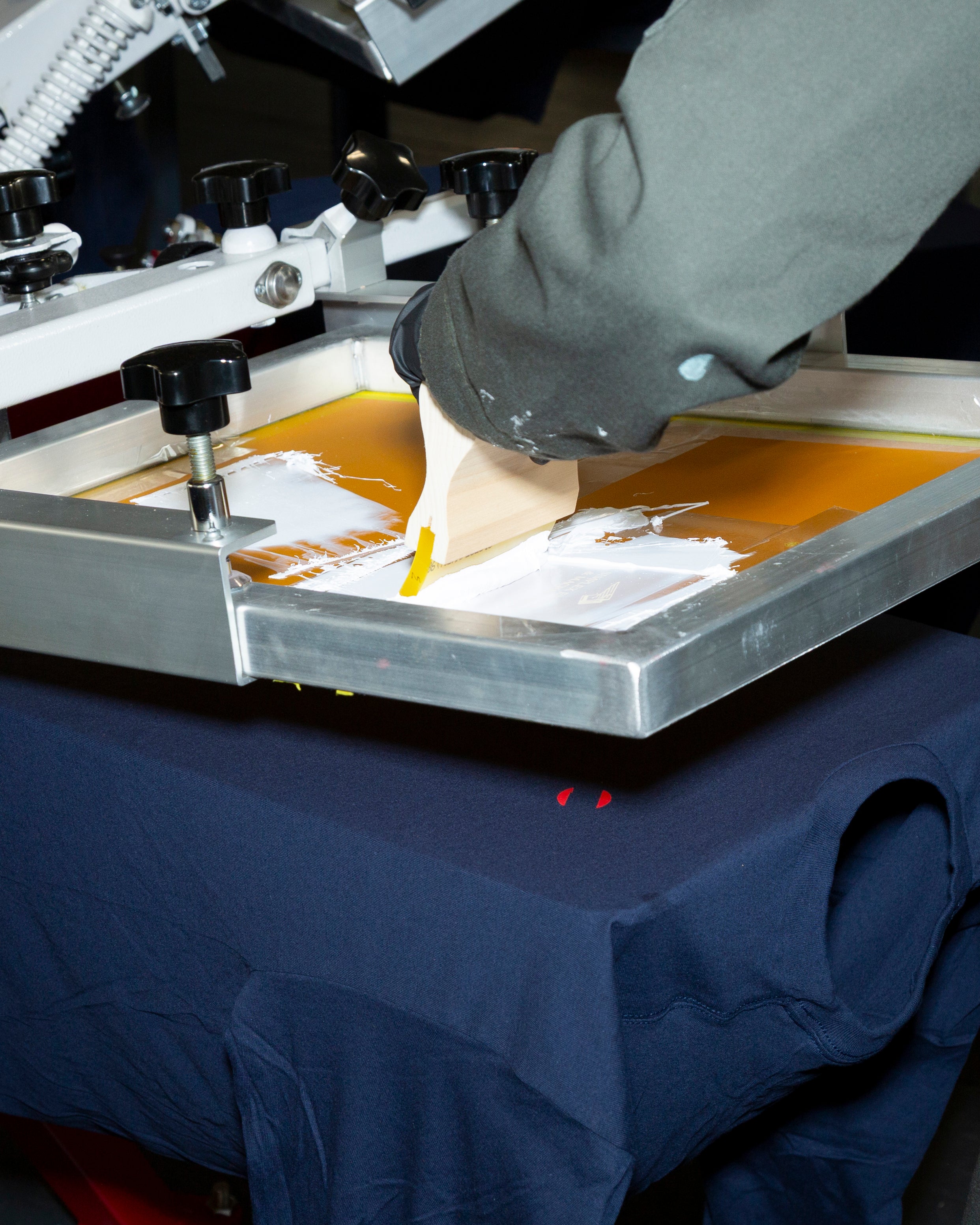 A close up of hand screen printing a custom design with precision at Frontside Factory in Fall River MA